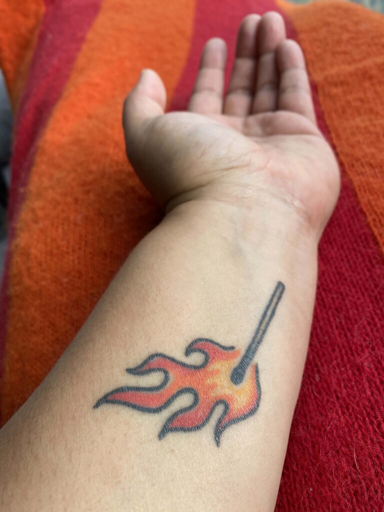 tattoo of a lit match on the inside of my forearm
